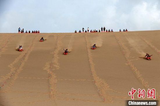 6月13日，敦煌鳴沙山月牙泉景區(qū)舉辦滑沙比賽?！垥粤?攝
