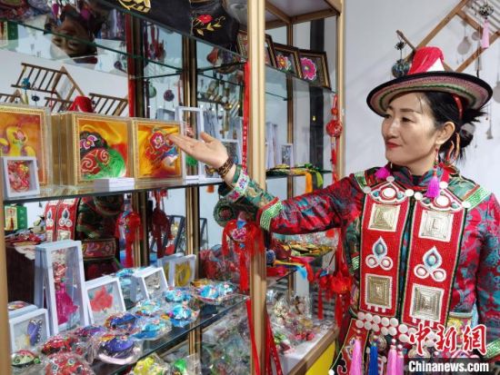 圖為身著民族服飾的隴原巧手展示手工藝品。(資料圖) 徐雪 攝