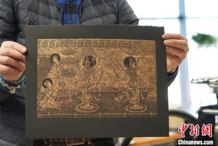 圖為手工書藝人展示敦煌雕版壁畫印刷品?！【琶赖┰?　攝