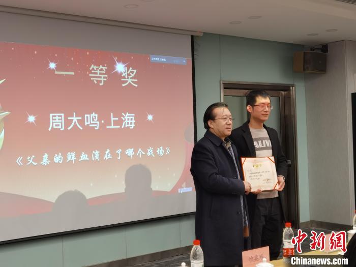 圖為作家、西北師范大學新聞與傳媒學院院長徐兆壽頒發(fā)一等獎證書，代領(lǐng)獎?wù)呱吓_領(lǐng)獎?！钅?攝