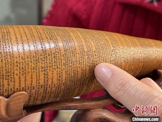 圖為長約二十公分的長條葫蘆雕刻佛教經(jīng)文作品。　張婧 攝