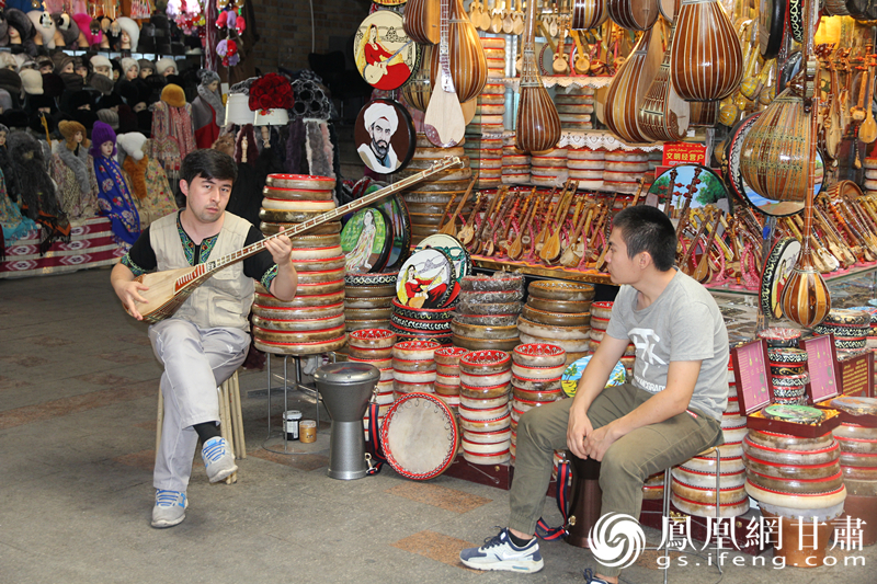 烏魯木齊二道橋巴扎內(nèi)，店主正在向客人展示樂器。楊文遠(yuǎn) 攝