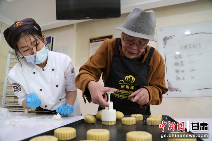當(dāng)日，受邀參加活動(dòng)的臺(tái)胞臺(tái)屬代表、兩岸婚姻及子女、在甘臺(tái)商代表等歡聚一堂。圖為77歲的在甘臺(tái)胞潘天鑒制作月餅。九美旦增 攝