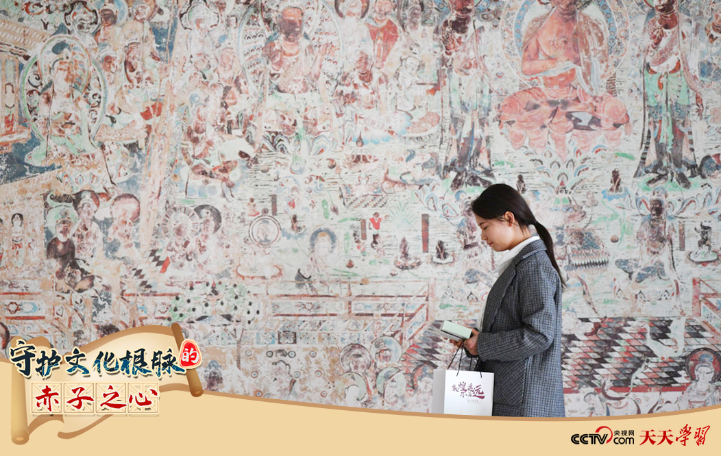 2023年4月25日，敦煌研究院文物數(shù)字化保護(hù)團(tuán)隊(duì)創(chuàng)意營(yíng)銷人員廖雪婷從一幅高保真復(fù)制壁畫前走過。