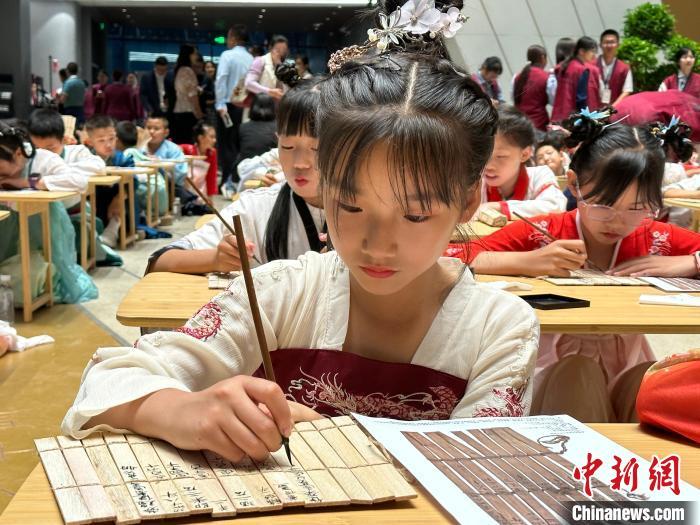 圖為小朋友在甘肅簡牘博物館練習(xí)書法?！≈行律缬浾?戴文昌 攝